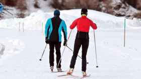 Una foto de dos esquiadores en la nieve con ropa de abrigo