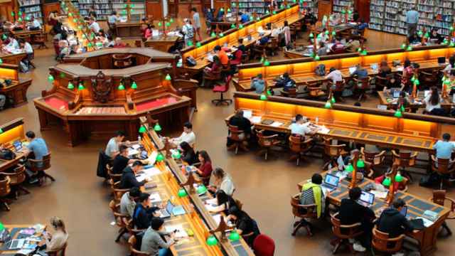 Varios estudiantes y profesores en una biblioteca americana