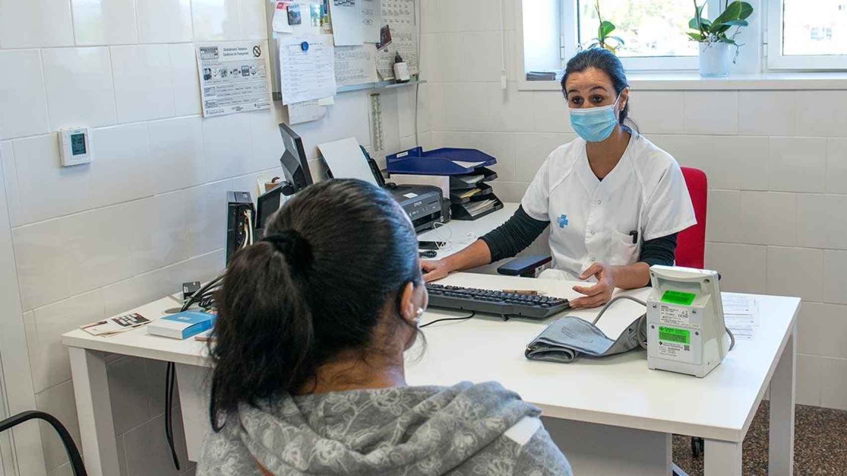 Una trabajadora sanitaria atiende a una paciente en uno de los ambulatorios de Cataluña / Glòria Sánchez (EP)