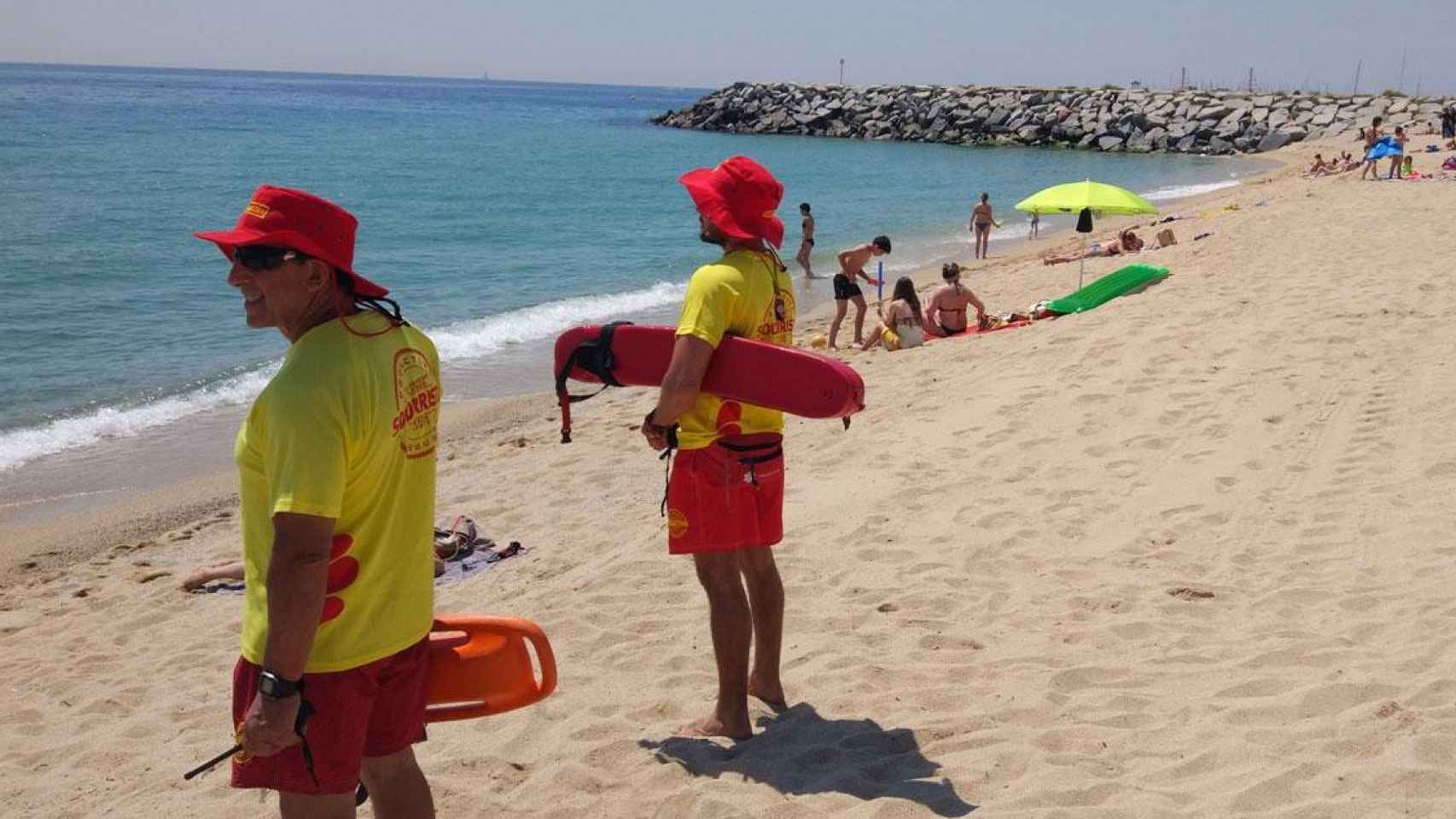 Dos socorristas y varios bañistas en una de las playas de Cataluña / PROACTIVA