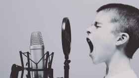 Niño gritando a un micrófono como símbolo de 'Mi voz son mis manos': una campaña por la inclusión / UNSPLASH