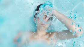 Un niño aguanta la respiración debajo del agua de una piscina