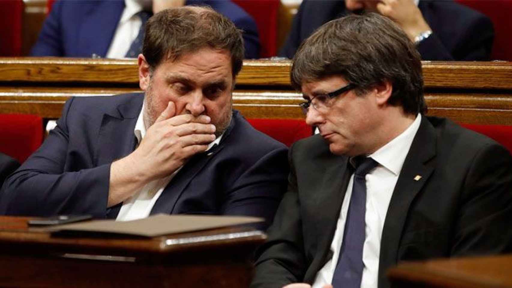 El presidente catalán, Carles Puigdemont (d) y el vicepresidente económico, Oriol Junqueras, hablan en el Parlament / EFE