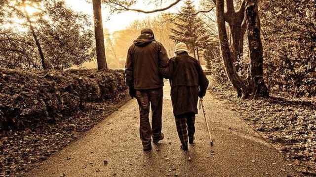Una pareja de ancianos pasea por un parque