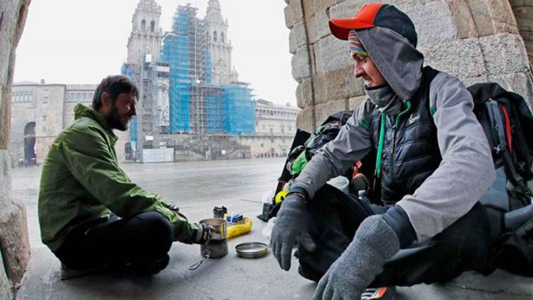 Dos peregrinos checos se cobijan del frío en la plaza de Obradoiro de Santiago de Compostela (La Coruña) / EFE