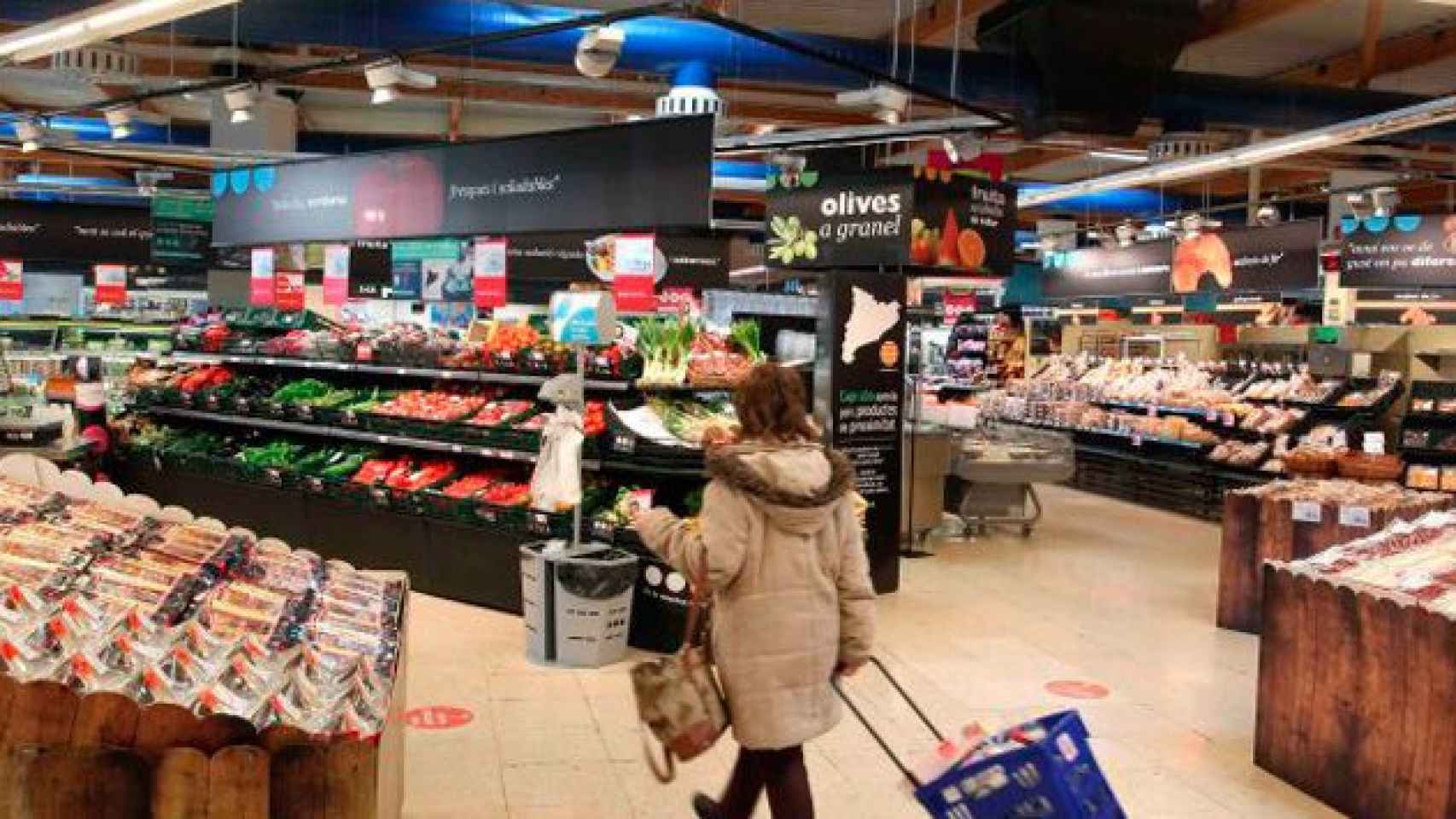 Imagen de una mujer en la sección de alimentos frescos de un supermercado / EFE