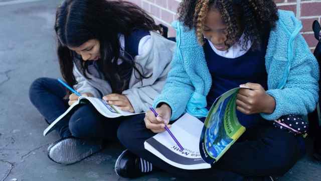 Dos niñas leen sus libros de texto / PEXELS