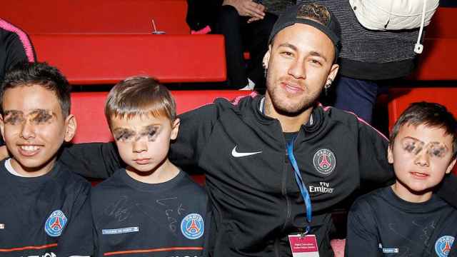 El futbolista brasileño Neymar posa junto a tres niños durante la visita al hospital infantil parisino Necker / EFE
