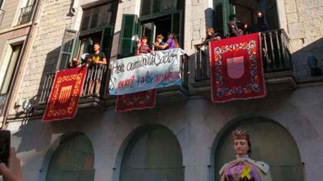 Jóvenes independentistas ocupando el balcón del Ayuntamiento de Girona. Debajo, el gigante de la ciudad con un lazo amarillo / @CDRGironaSalt