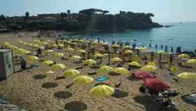 Una imagen de una playa de Palamós este domingo invadida por sombrillas amarillas