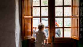 Niño mirando por la ventana, como el que dejó solo en casa una mujer que se enfrenta a un año de cárcel / PEXELS
