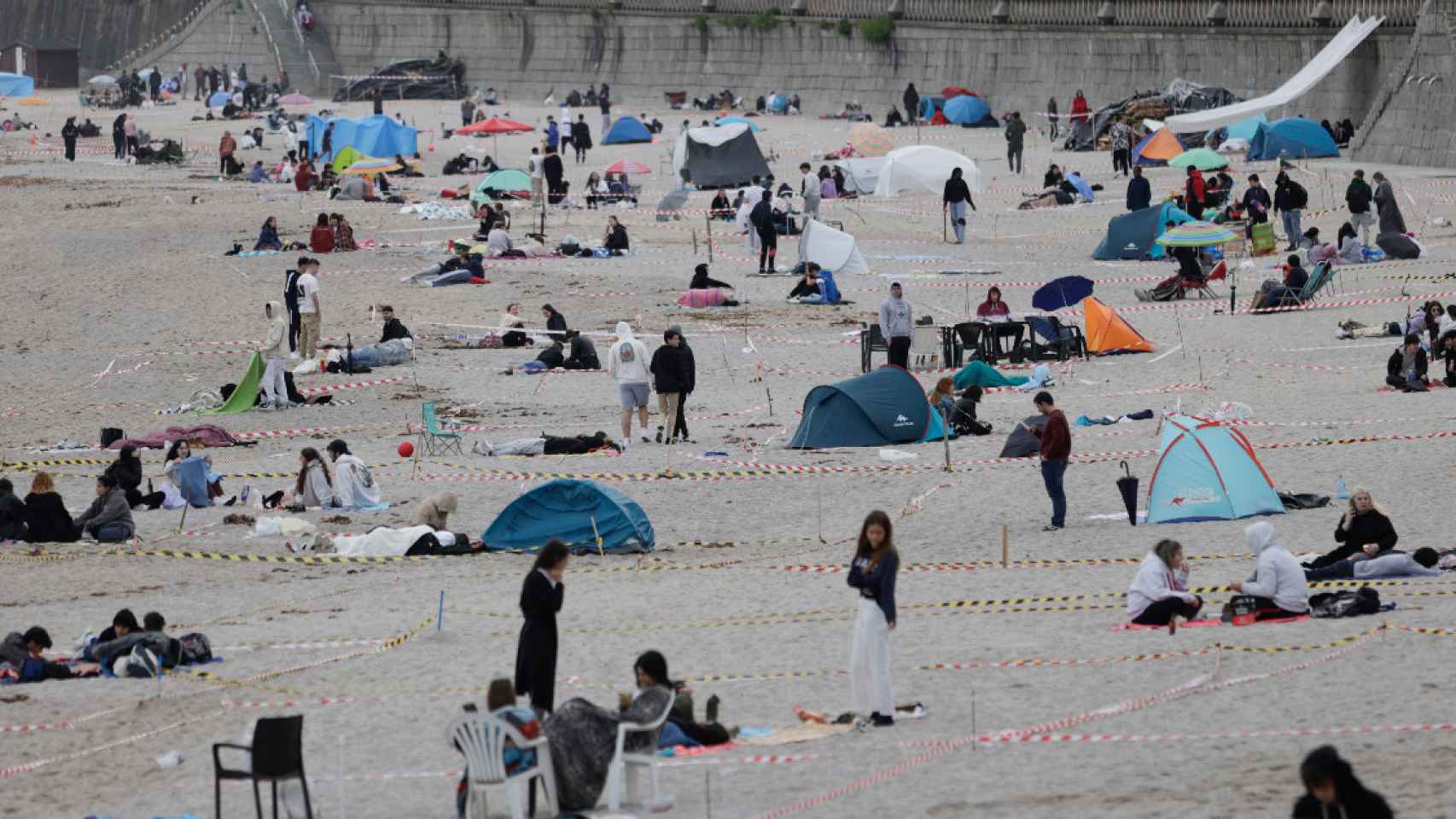 Cientos de personas han pasado la noche en las playas de Riazor y Orzán, en la ciudad de A Coruña, reservando así espacio para la celebración de la noche de San Juan / CABALAR - EFE