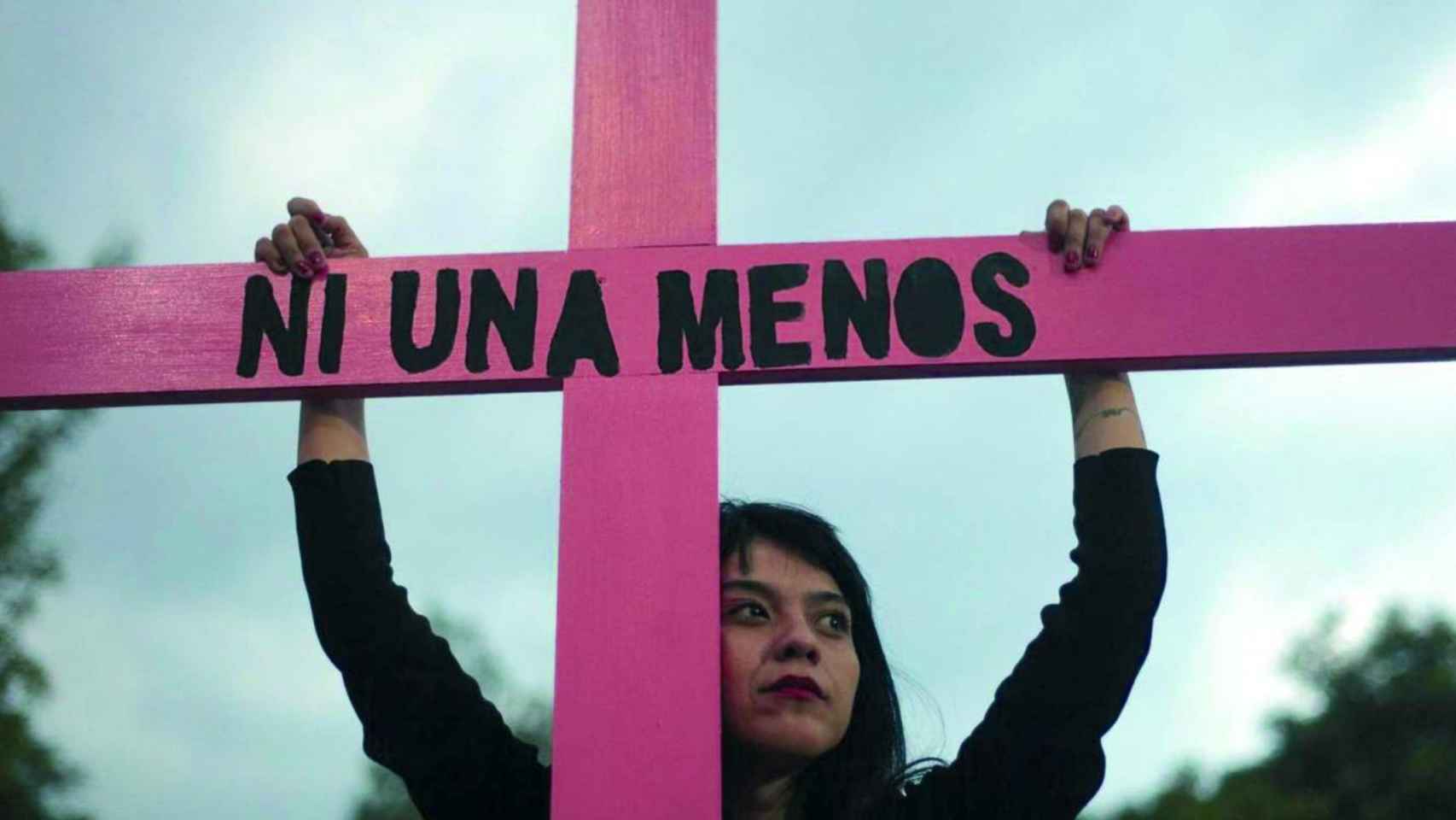 Una joven sujeta una cruz durante una marcha contra la violencia machista / EFE