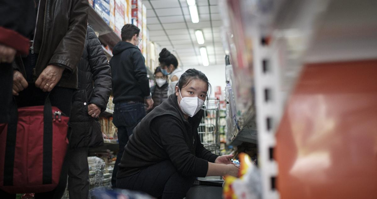 Una mujer china limpia las estanterías de un supermercado en Barcelona / PABLO MIRANZO (CG)