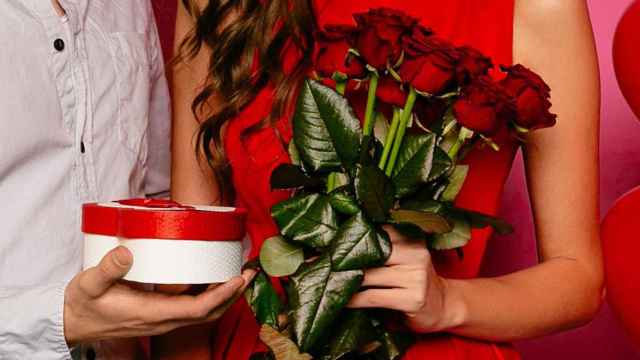 Un hombre regala rosas rojas a su pareja por San Valentín / FREEPIK