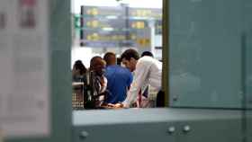 Personal de 'check-in' de Vueling atendiendo a un pasajero en el aeropuerto de El Prat / EFE