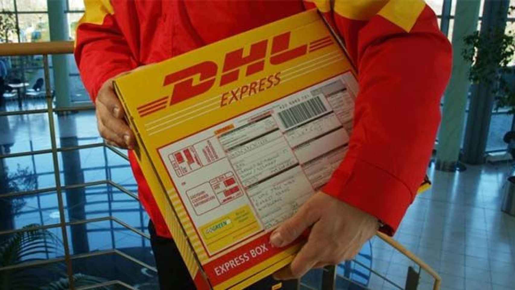 Hombre con un paquete, pieza de la red logística del e-commerce / DHL