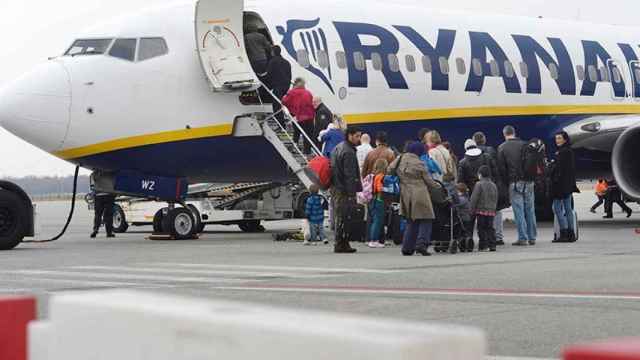 Un grupo de pasajeros hace cola para entrar en un avión de Ryanair / EFE