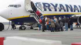 Un grupo de pasajeros hace cola para entrar en un avión de Ryanair / EFE