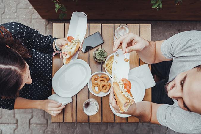 Dos viajeros 'foodies' comiendo en un restaurante que han encontrado gracias a la tecnología / BOOKING
