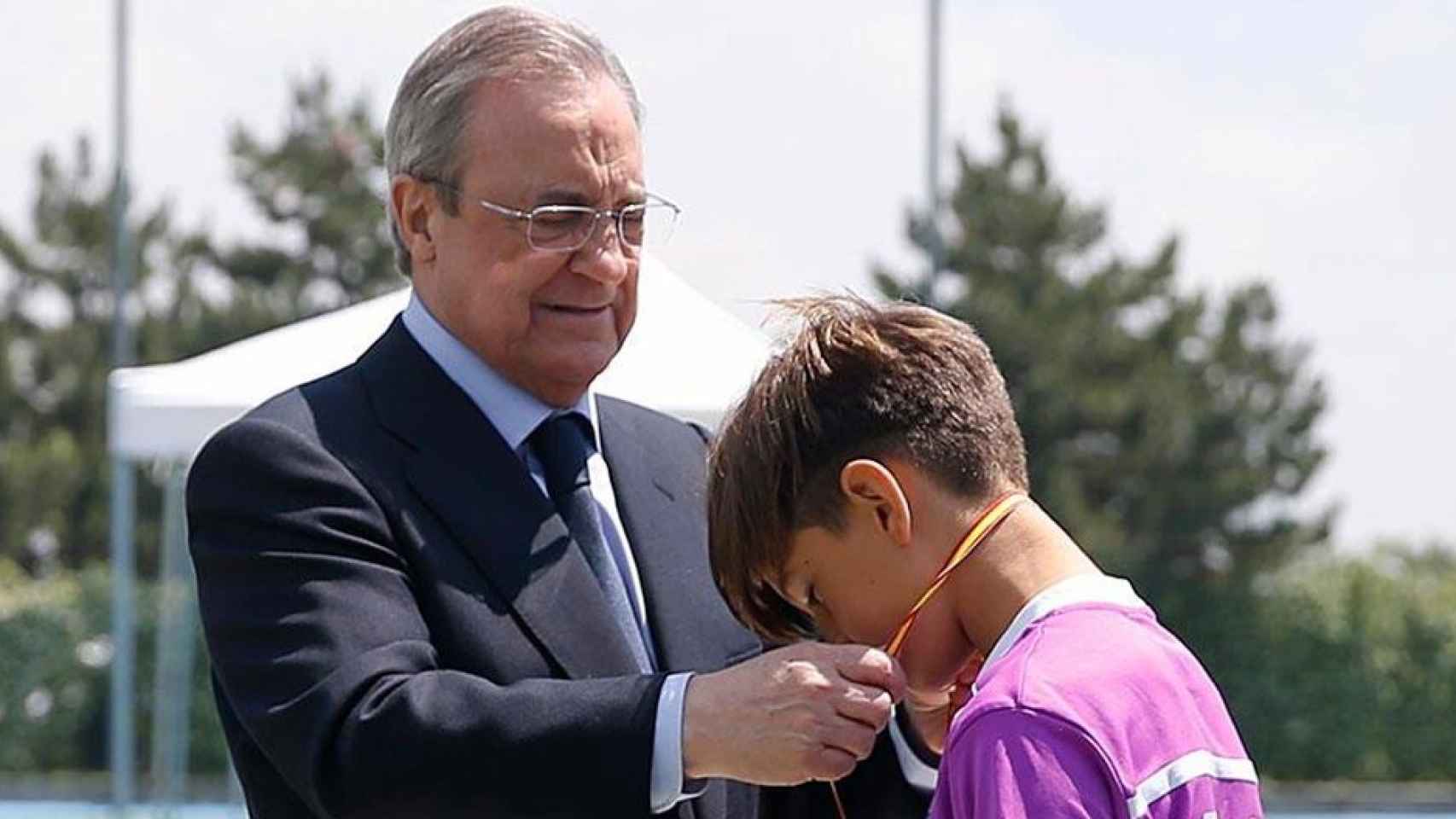 Florentino Pérez, presidente del Real Madrid, hace entrega de unas medallas a unos niños / REALMADRID.COM