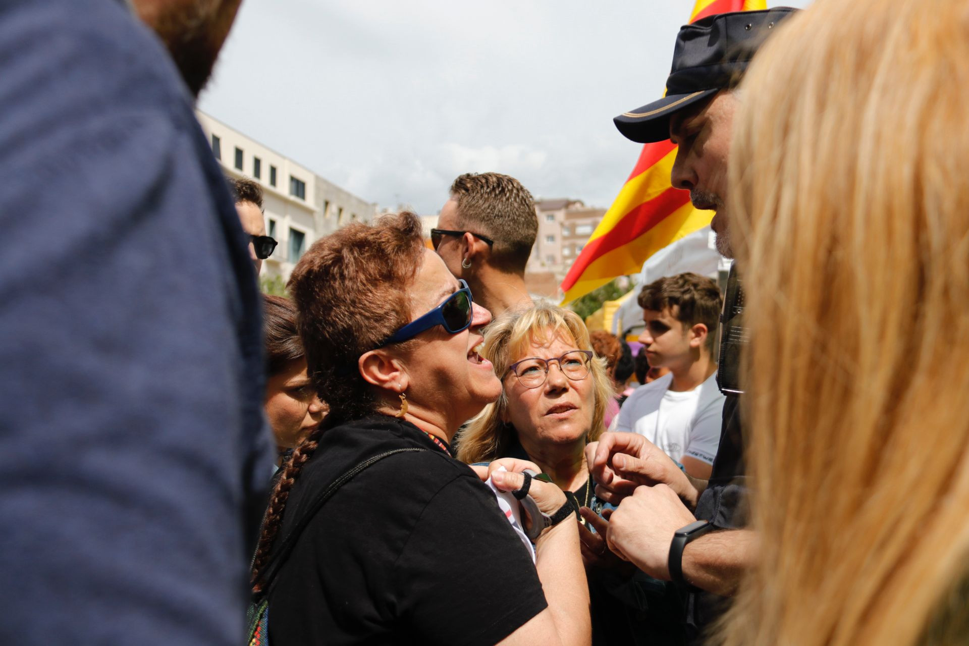 Dos mujeres protestan ante un Mosso d'Esquadra en el escrache a la parada de Sant Jordi de Vox en Sabadell / GALA ESPÍN