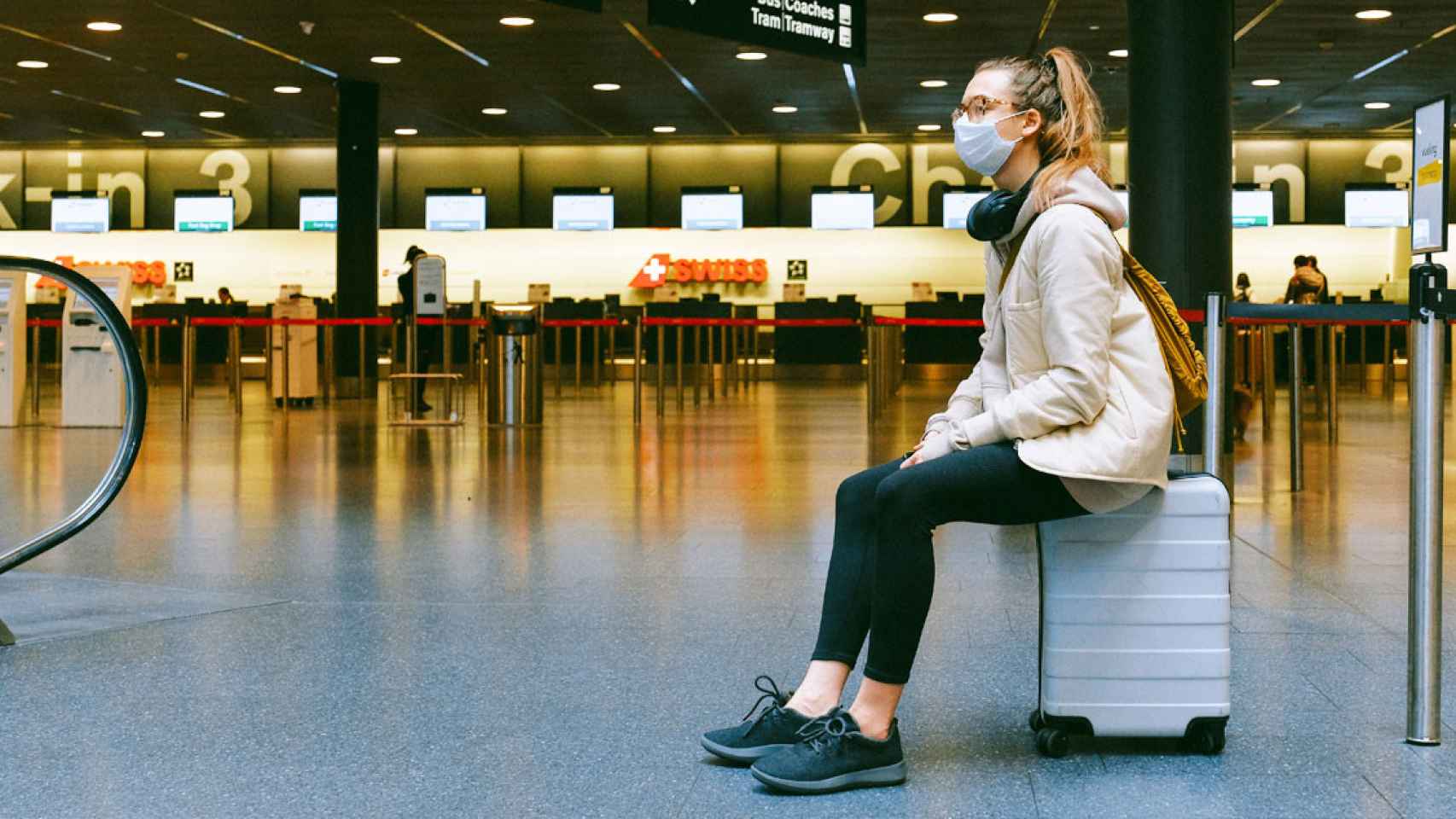 Imagen de una pasajera con mascarilla en un aeropuerto / Pexels