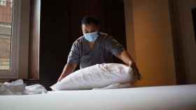 Una trabajadora de un hotel haciendo una cama / EP