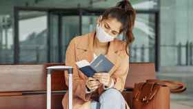 Una joven comprueba su pasaporte antes de viajar durante la pandemia del Covid-19 / EUROPA PRESS - CEAV