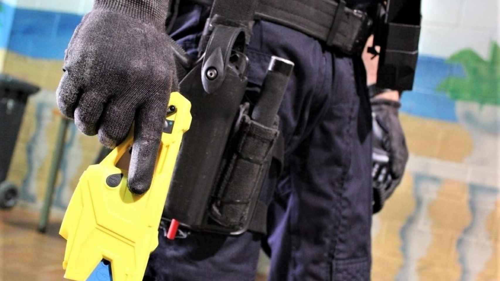 Un agente de los Mossos d'Esquadra sujeta una pistola eléctrica / EP