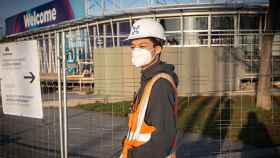 Un trabajador asiático con mascarilla junto al pabellón del Mobile World Congress (MWC) tras la cancelación de la feria por la crisis del coronavirus / EP