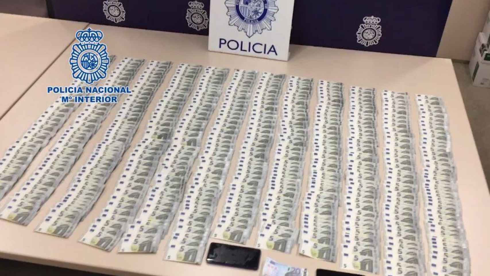 Imagen de la Policía Nacional con multitud de billetes falsos de cinco euros incautados / CNP