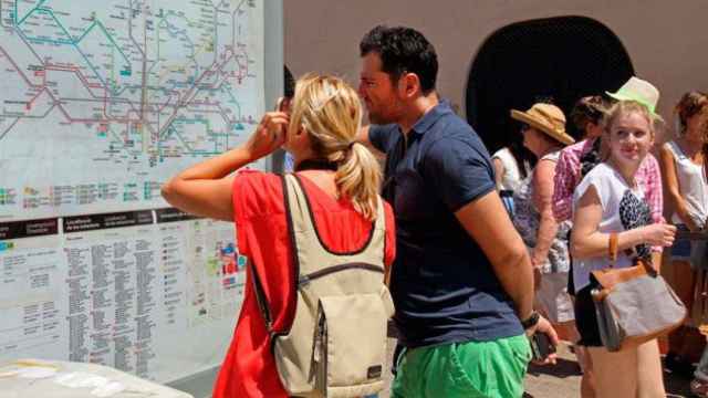 Dos turistas observan un panel de información del Metro de Barcelona / EFE