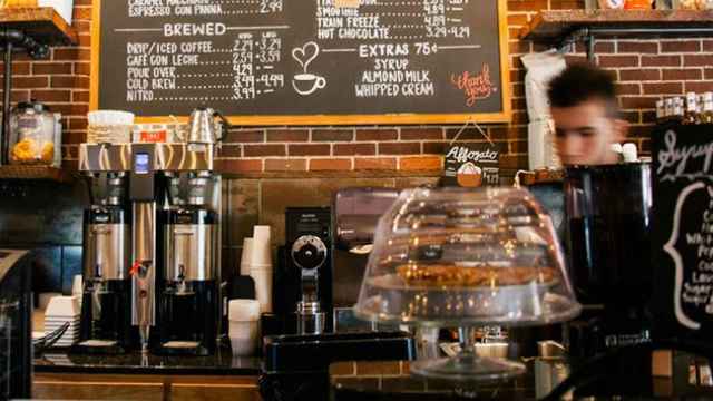 Un hombre joven que trabaja tras la barra de una cafetería