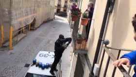 Un agente de la Policía Nacional le entrega dulces a Toñi desde el balcón / TWITTER