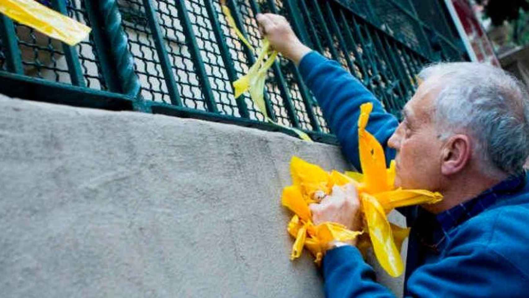 Un miembro de los GDR quita lazos amarillos de la vía pública