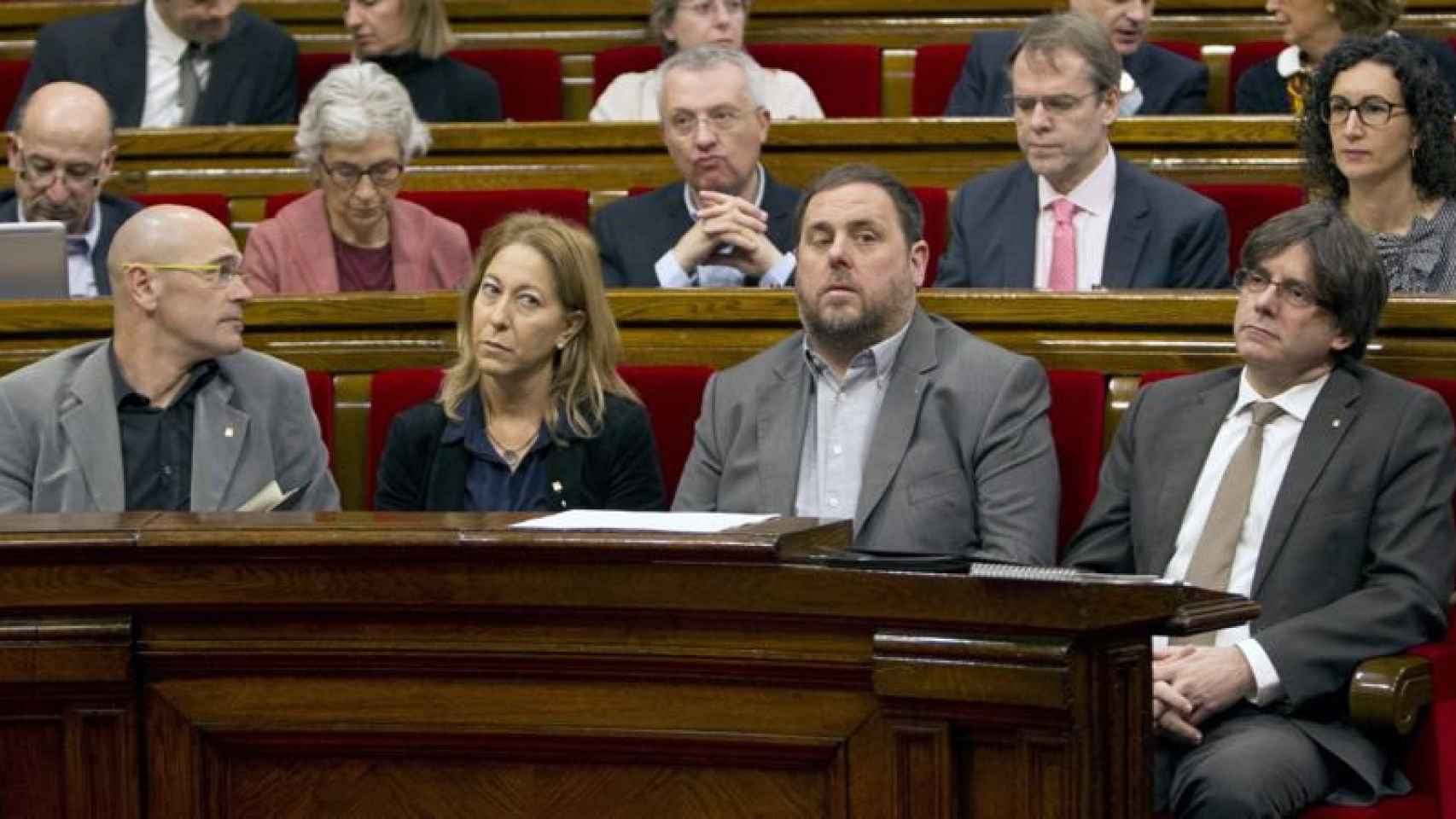 Raül Romeva, Neus Munté, Oriol Junqueras y Carles Puigdemont, en su escaño parlamentario.