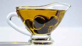 Una taza de aceite de oliva con aceitunas dentro