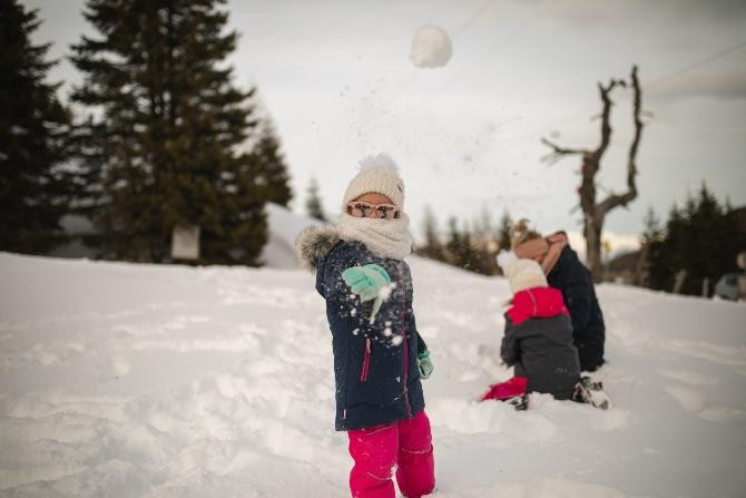 Niños tirándose bolas de nieve tras esquiar / Stefan Pasch en UNSPLASH