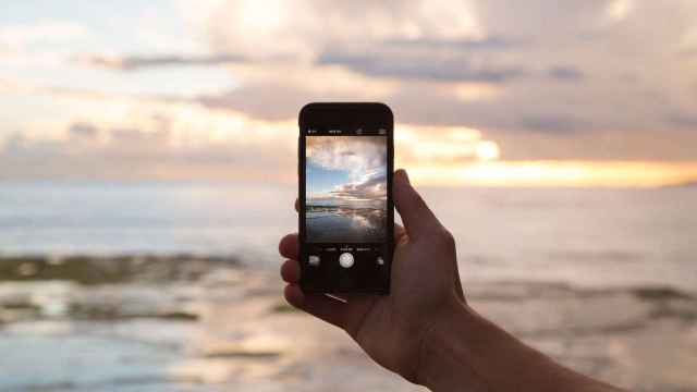 Un iPhone sacando fotos de la puesta de Sol en el mar / CG