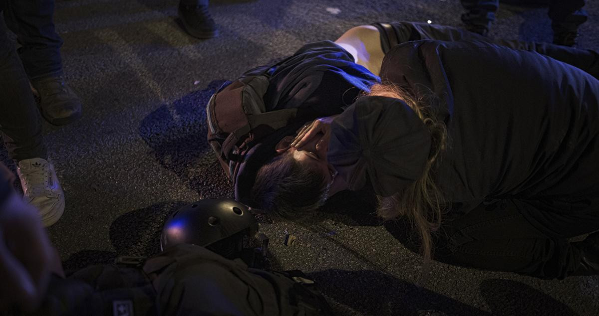 Una persona permanece inconsciente en el suelo, durante la tercera noche de disturbios / PM