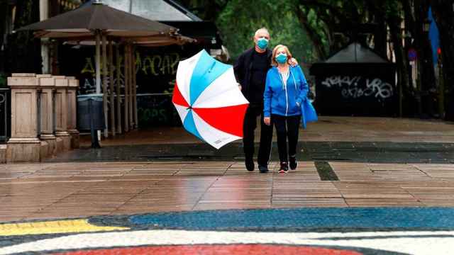 Una pareja pasea por Las Ramblas de Barcelona con mascarilla / EFE