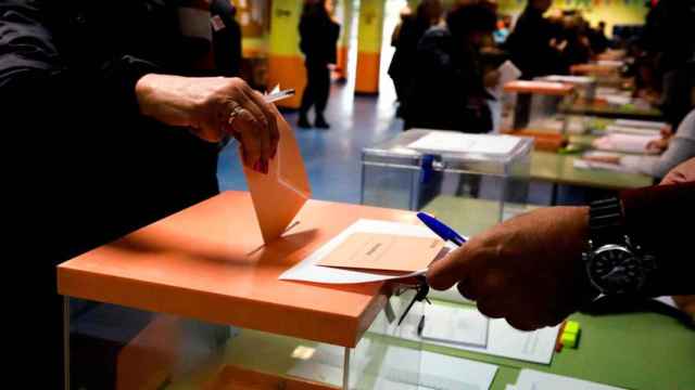 Varios electores depositan sobres con las papeletas en las urnas habilitadas para el 10N / EFE