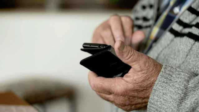 Uno de muchos ancianos, potencial víctima de estafa, con un móvil en las manos / PXFUEL