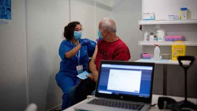 Una sanitaria administra la tercera dosis contra el Covid a un hombre en el punto de vacunación de Fira de Barcelona / David Zorrakino (EP)