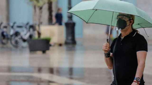 Una persona sostiene un paraguas bajo la lluvia, que podría dejar inundaciones / Rober Solsona (EP)