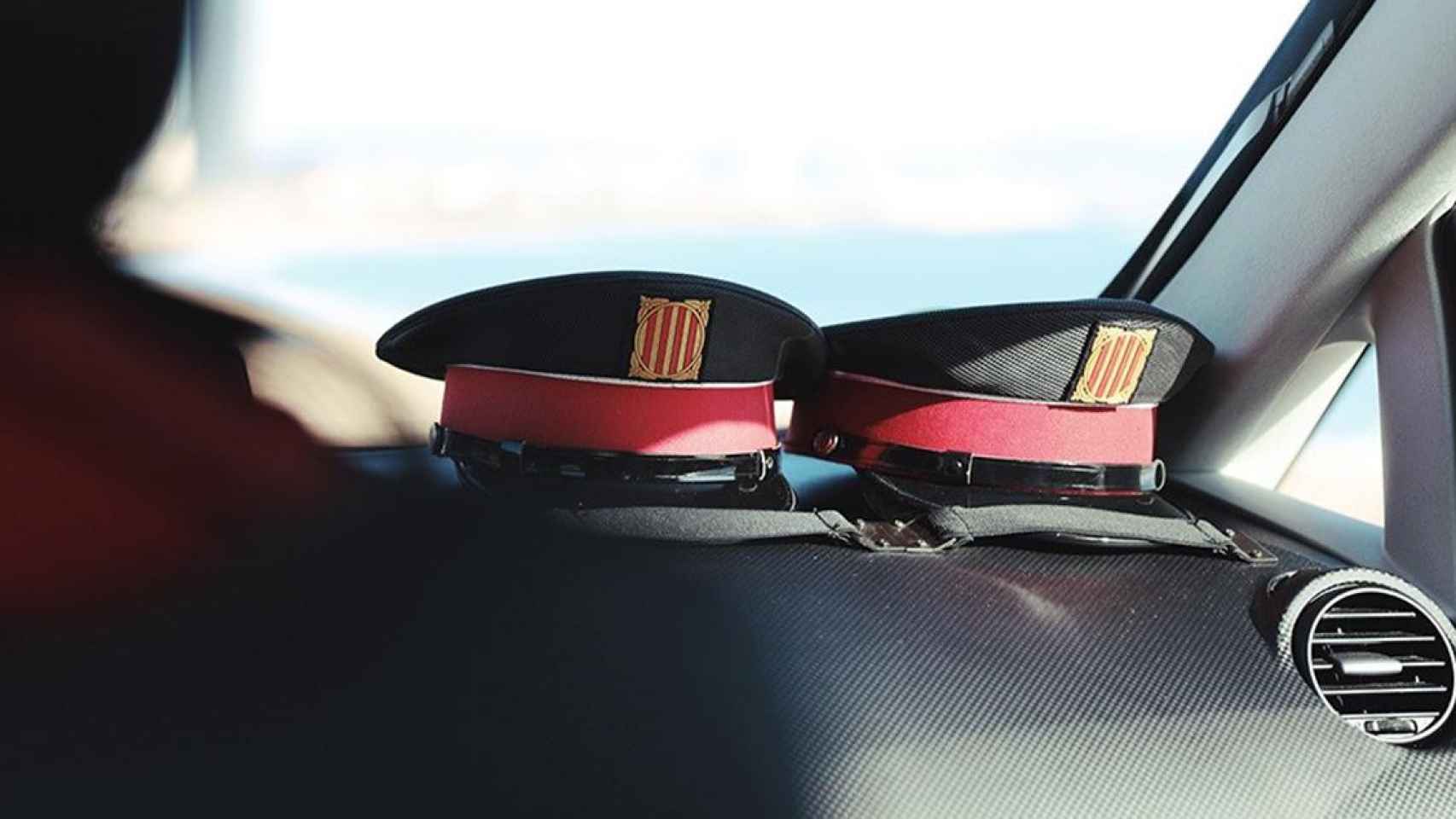 Dos gorras de mossos dentro de un coche / EUROPA PRESS