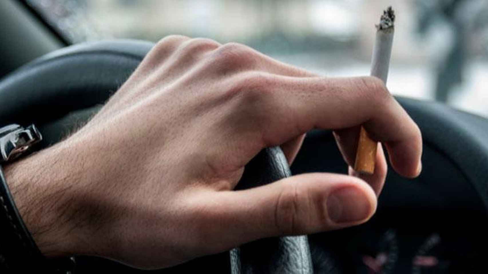 Un hombre fuma un cigarrillo en el coche mientras conduce, en una imagen de archivo / CG