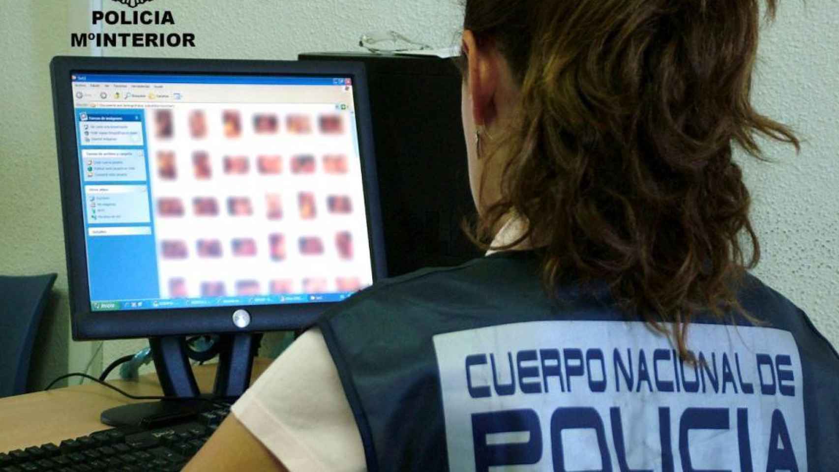 Una agente de la Policía Nacional examina la carpeta de archivos de un presunto pederasta / CG