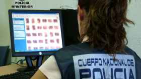 Una agente de la Policía Nacional examina la carpeta de archivos de un presunto pederasta / CG